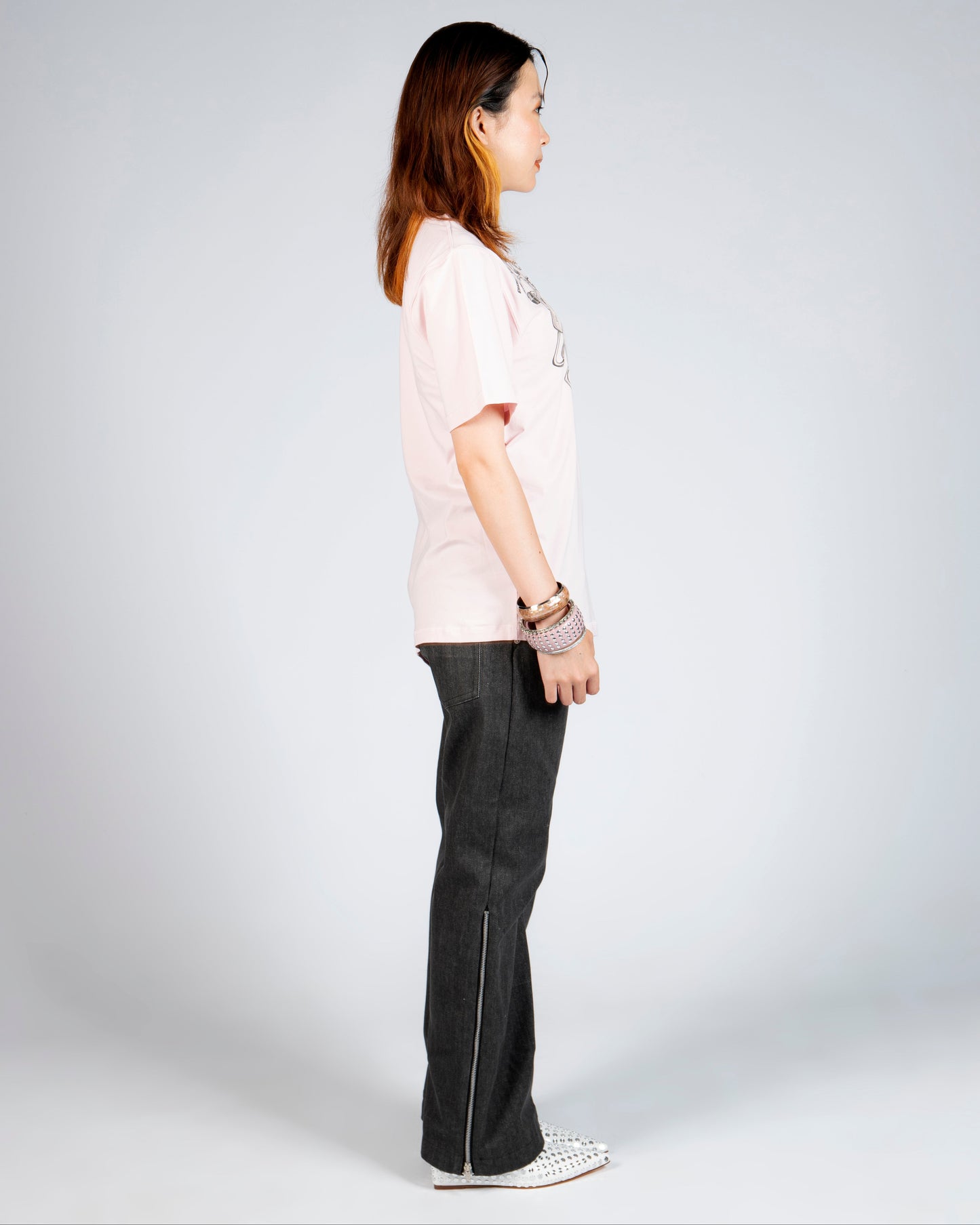Side view of MINASEONG washed black wide-leg jeans with silver side zipper on model