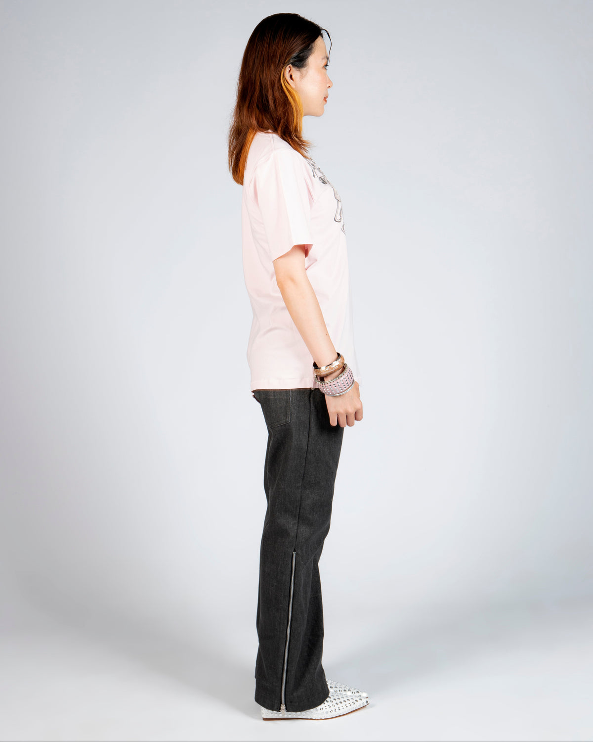 Side view of MINASEONG washed black wide-leg jeans with silver side zipper on model