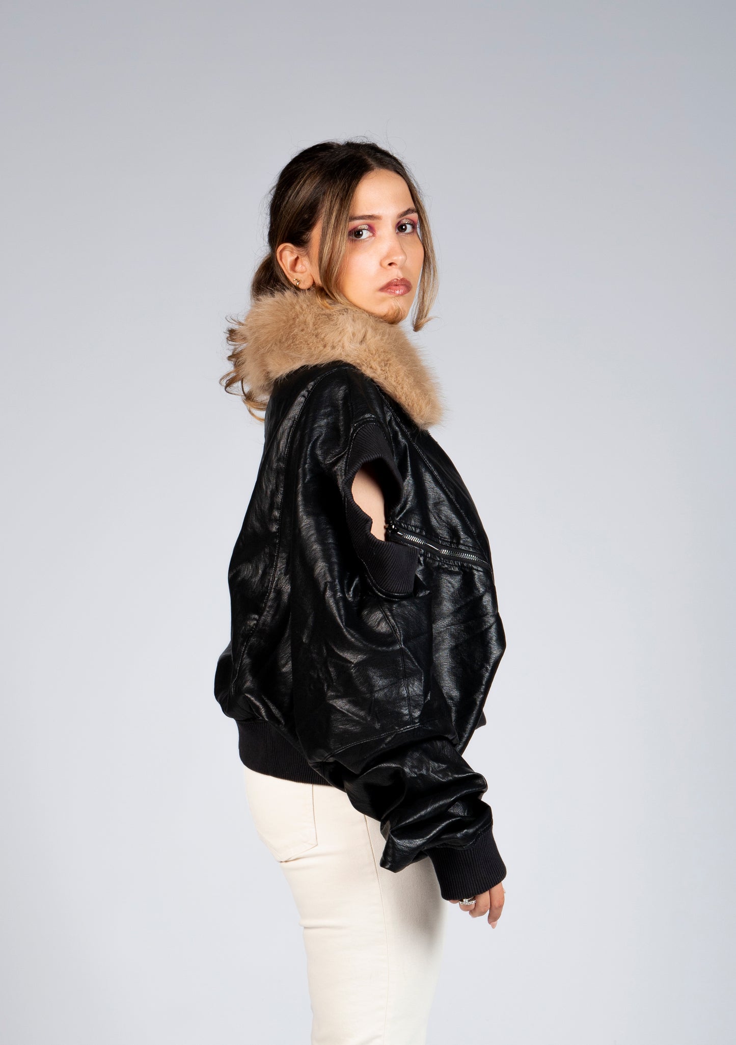 Side view of MINASEONG black faux leather bomber jacket with faux fur collar