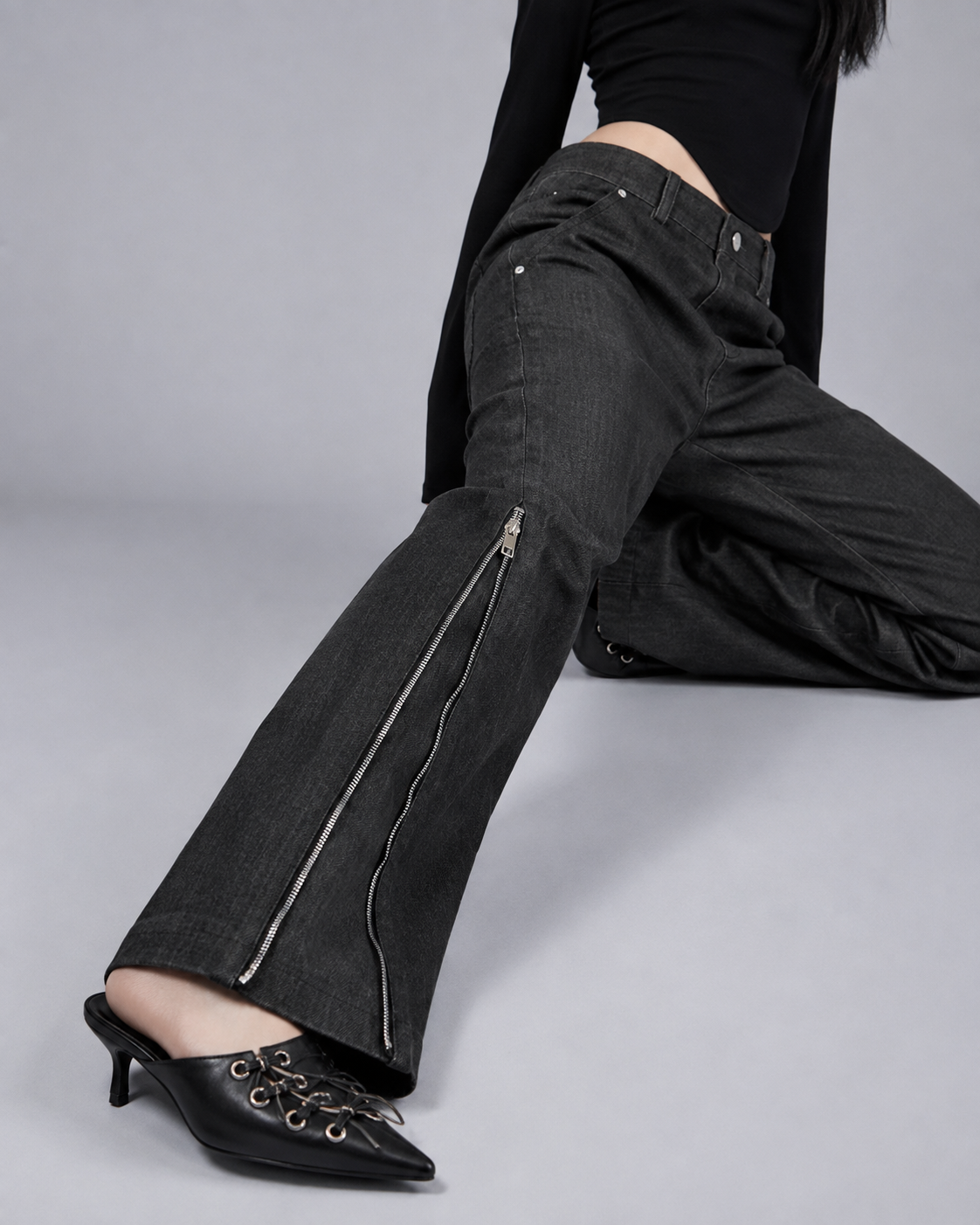 Close-up of MINASEONG washed black denim jeans with silver side zipper